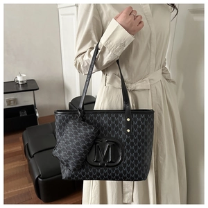 Dettaglio della grande borsa tote grigio scuro con stampa M e piccola pochette coordinata