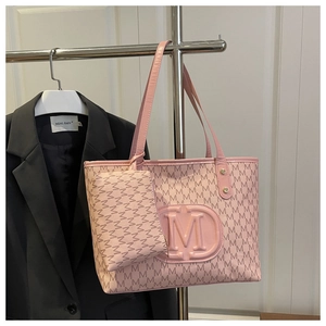 Pink tote bag detail with textured M-letter monogram print and circular embossed logo
