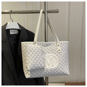Detail of white monogram tote bag with matching pouch and embossed M logo charm