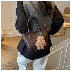Detailed back view of a vintage dark brown tote bag with adjustable strap and puppy charm
