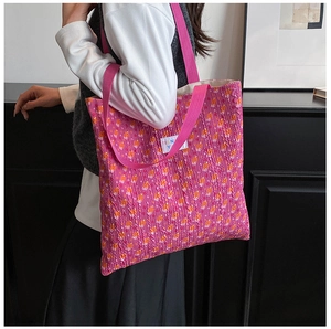 Close-up of pink bubble textured tote bag with floral pattern and woven handle strap