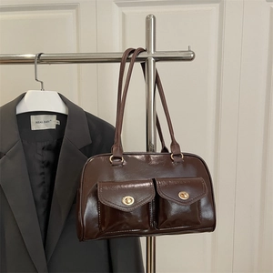 Dark brown patent leather underarm bag with gold turn-lock pockets and slim shoulder strap