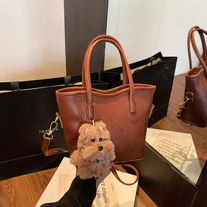 Brown vintage PU leather shoulder bag with a cute plush dog charm and long strap