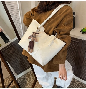 Détail du sac fourre-tout blanc avec texture plissée et un pendentif lapin en peluche