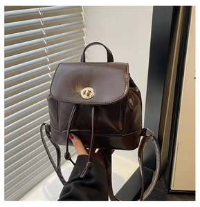 Detail of mini dark brown PU leather backpack with gold clasp and drawstring closure
