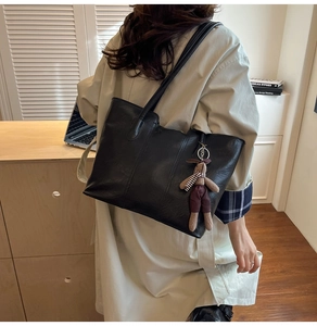 Sac fourre-tout noir en similicuir avec pendentif lapin mignon porté sur l'épaule