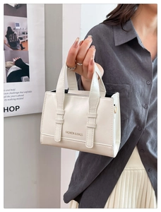 Detail of cream PU leather mini tote bag with gold branding and crossbody strap