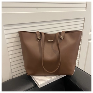 Détail du sac cabas en cuir PU marron avec une barre décorative élégante en métal doré