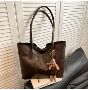 Détail du sac cabas marron foncé avec texture cuir rétro et breloque lapin mignonne