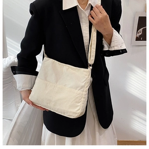 Detail of soft cream corduroy tote bag showing textured fabric and wide shoulder strap
