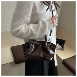 Détail d'un sac seau marron chocolat brillant à plis et finitions dorées