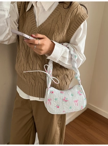 Detailed view of the textured floral fabric and knot design on the canvas shoulder bag