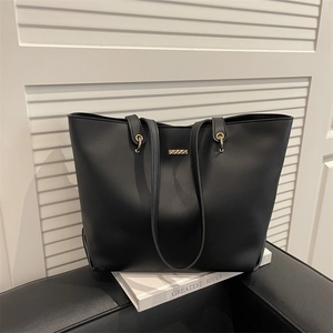 Sac fourre-tout minimaliste en cuir noir mat avec détails dorés sur fond blanc