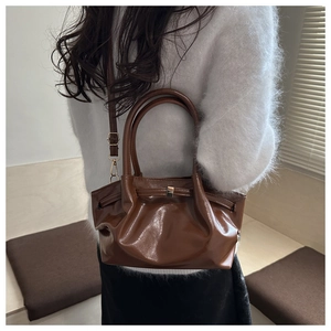 Gros plan sur un sac seau marron vintage avec texture plissée et bandoulière réglable