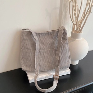 Light gray corduroy tote bag with dual front pockets and adjustable shoulder strap