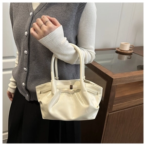 Dettaglio borsa a mano crema arricciata in pelle lucida con fibbia centrale elegante