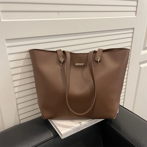 Sac fourre-tout minimaliste en cuir marron avec détails dorés sur fond bicolore