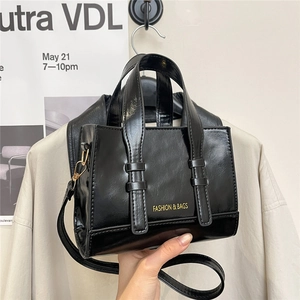 Sac à main tendance en similicuir noir brillant avec logo jaune et bandoulière réglable