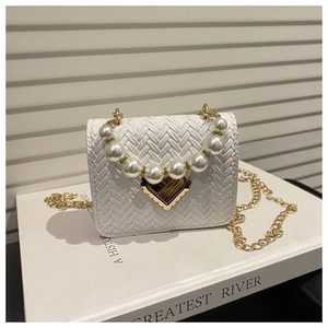 Detail der weißen gewebten Mini-Tasche mit Goldherz-Verschluss und Perlengriff