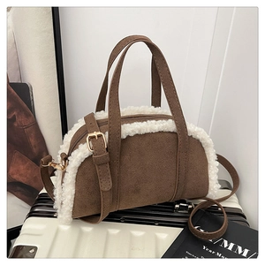 Détail du sac polochon en daim avec bordure en laine d'agneau et bandoulière réglable