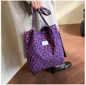 Detail van de paarse bloemen shopper met abstracte print en wit merklabel detail
