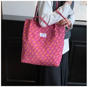 Gedetailleerde close-up van de roze bloemen tote bag met geplooid textiel en merklabel