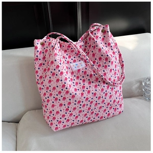 Detail van de roze bloemen tote bag met gewatteerde stof en een kleurrijk geweven label