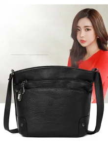 Close-up of black litchi pattern leather multi-layer bucket bag with metal zippers