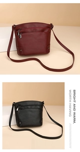 Macro detail of multi-layer zipper crossbody bag featuring leather texture and metal rivets