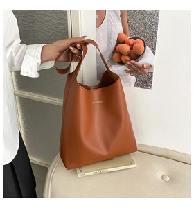 Détail d'un sac cabas marron caramel vintage avec lettrage FASHION sur cuir PU texturé