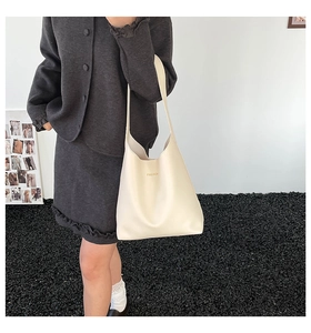 Fashion tote bag in cream white leather shown on model for a stylish commute look
