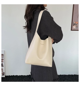 Side view of beige tote bag with Fashion lettering shown on shoulder with minimalist style