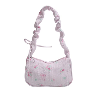 Pink floral drawstring underarm bag with ruffled strap and textured fabric design