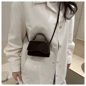 Détail du mini sac bandoulière marron foncé en cuir mat avec poignée supérieure chic