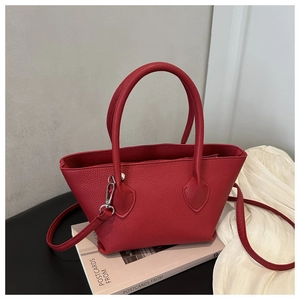 Close-up of red litchi texture bucket bag with dual handles and silver metal hardware