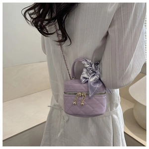 Detail of lavender quilted mini bag with floral silk ribbon and gold chain strap