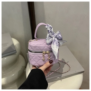 Detail of purple quilted leather vanity bag with gold ball zipper and silk scarf