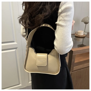 Close-up of beige leather shoulder bag with Fashion & Bags lettering and zipper closure