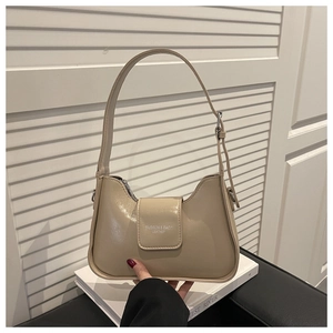 Detail of cream leather shoulder bag with metallic buckle and fashion branding text