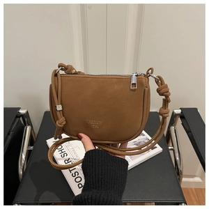 Close-up of brown matte crossbody bag with knot strap and silver metallic hardware