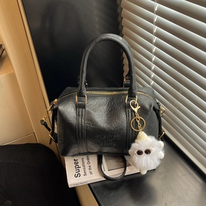 Sac Boston en cuir texturé noir avec fermeture dorée et accessoire en peluche