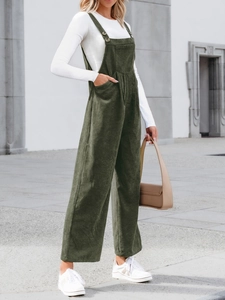 Detail of dark green corduroy overalls with adjustable straps and wide leg texture