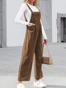 Detailed texture of brown corduroy overalls with adjustable straps and wide-leg design