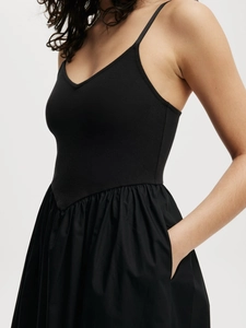 Elegante vestido largo negro con cuello en V, tirantes finos y falda con bolsillos