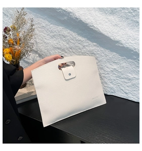 Détail d'une pochette enveloppe blanche avec texture grainée et poignée découpée