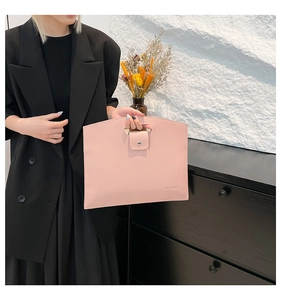 Close-up of pink lychee pattern texture and metal ring buckle on the handbag