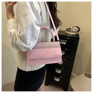 Detailed shot of pink leather handbag featuring a glitter flap and elegant shoulder strap