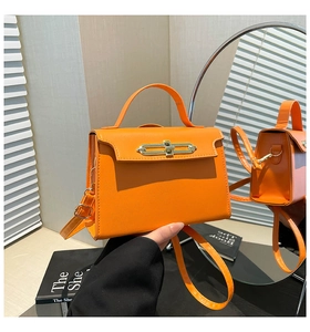 Dettaglio borsa in pelle arancione vivace con fibbia in metallo e riflesso nello specchio