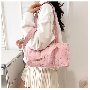 Detail of pink Boston bag with star patterns showing wide handles and zip closure