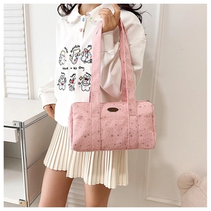 Detailed close-up of pink barrel bag featuring silver star prints and branding tag